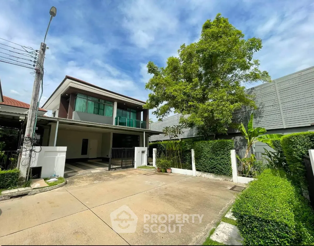 Modern two-story house with spacious driveway and lush greenery, perfect for family living.