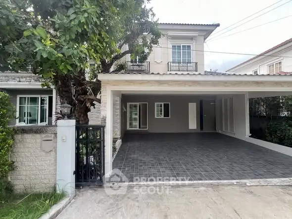 Charming two-story house with spacious driveway and lush greenery, perfect for family living.