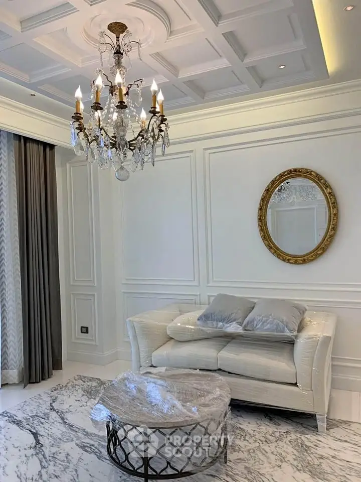 Luxurious living room with elegant chandelier and plush sofa in a sophisticated setting.