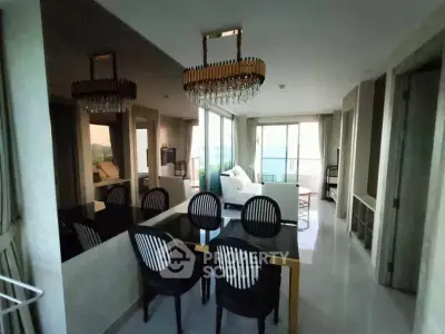 Luxurious open-plan living and dining area with elegant chandeliers and modern decor.