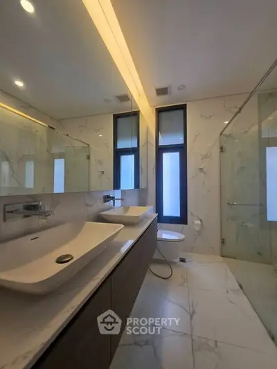 Luxurious modern bathroom with dual sinks and glass shower enclosure