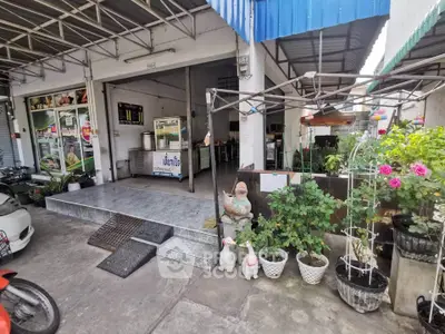 Charming commercial property with outdoor seating and vibrant plants, ideal for a cozy cafe or shop.