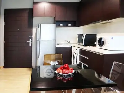 Modern kitchen with sleek appliances and stylish dining area in contemporary apartment.