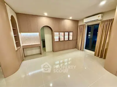 Spacious modern living room with built-in shelves and large windows for natural light.