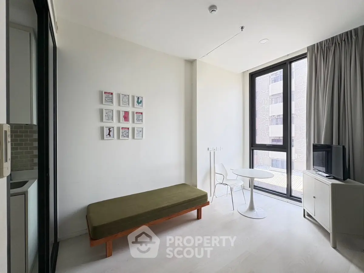 Modern minimalist living room with large windows and stylish decor in urban apartment.