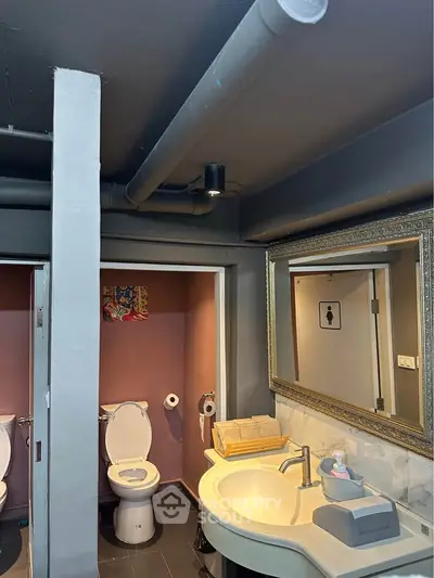 Modern bathroom with elegant mirror and dual toilets in a stylish setting.