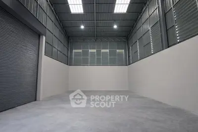 Spacious industrial warehouse with high ceilings and large roller door access.