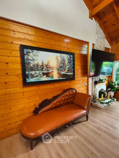 Charming living room with rustic wood paneling and elegant leather chaise lounge.