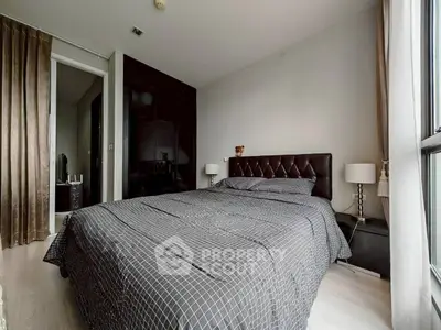 Modern bedroom with stylish decor and large window for natural light.