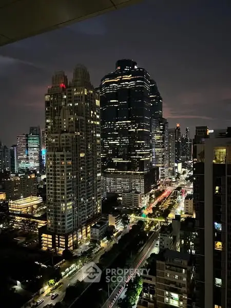 Stunning cityscape view of illuminated skyscrapers at night, showcasing urban living.