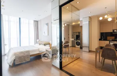Modern studio apartment with stylish decor and open layout, featuring a cozy bedroom and sleek kitchen.
