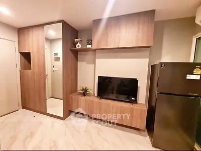 Modern living room with sleek wooden cabinetry and stainless steel fridge