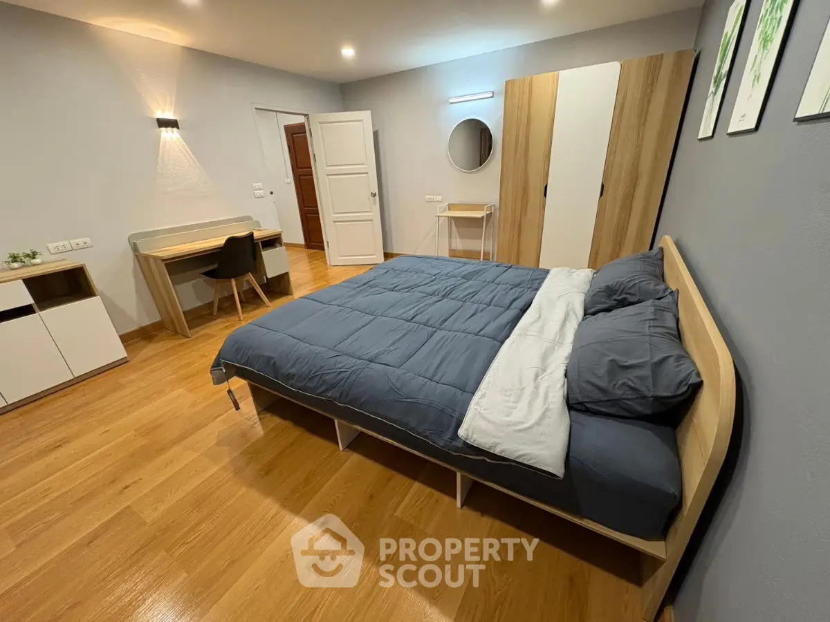 Modern bedroom with stylish furniture and wooden flooring