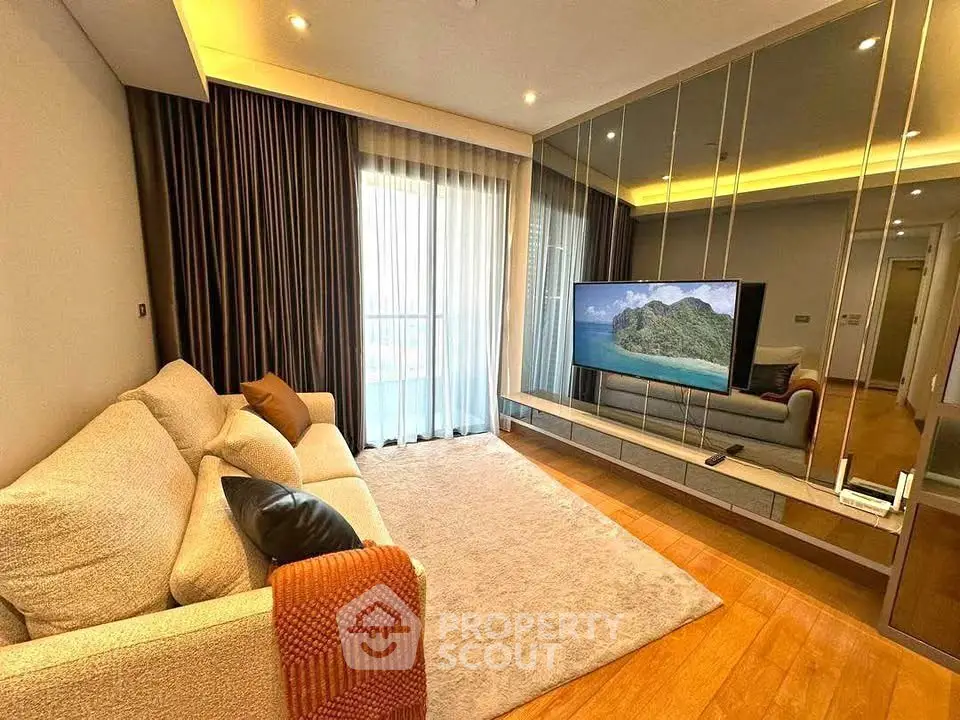 Luxurious living room with modern decor and large TV, perfect for relaxation.