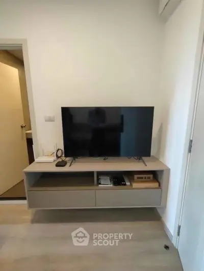 Modern living room with sleek TV stand and flat-screen TV, perfect for entertainment.