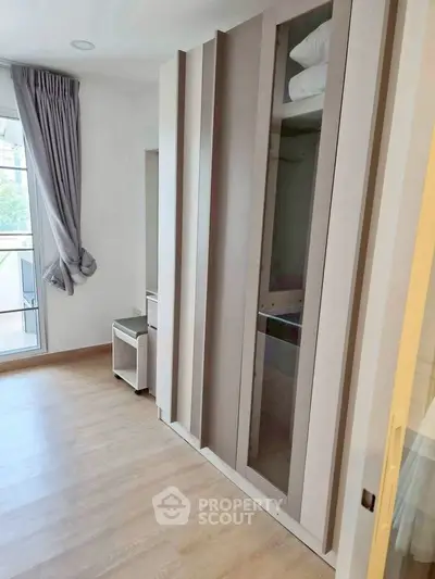 Modern bedroom with sleek wardrobe and balcony access