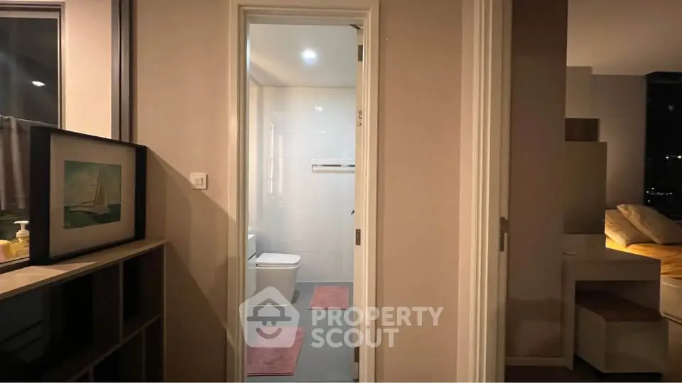 Modern apartment interior with bathroom and bedroom view, featuring sleek design and cozy ambiance.