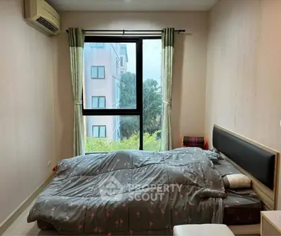 Cozy bedroom with large window offering a serene view, featuring a comfortable bed and air conditioning.