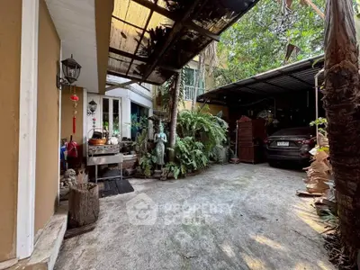 Charming outdoor parking area with lush greenery and covered carport