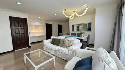 Spacious living room with elegant chandelier and modern dining area in a stylish apartment.