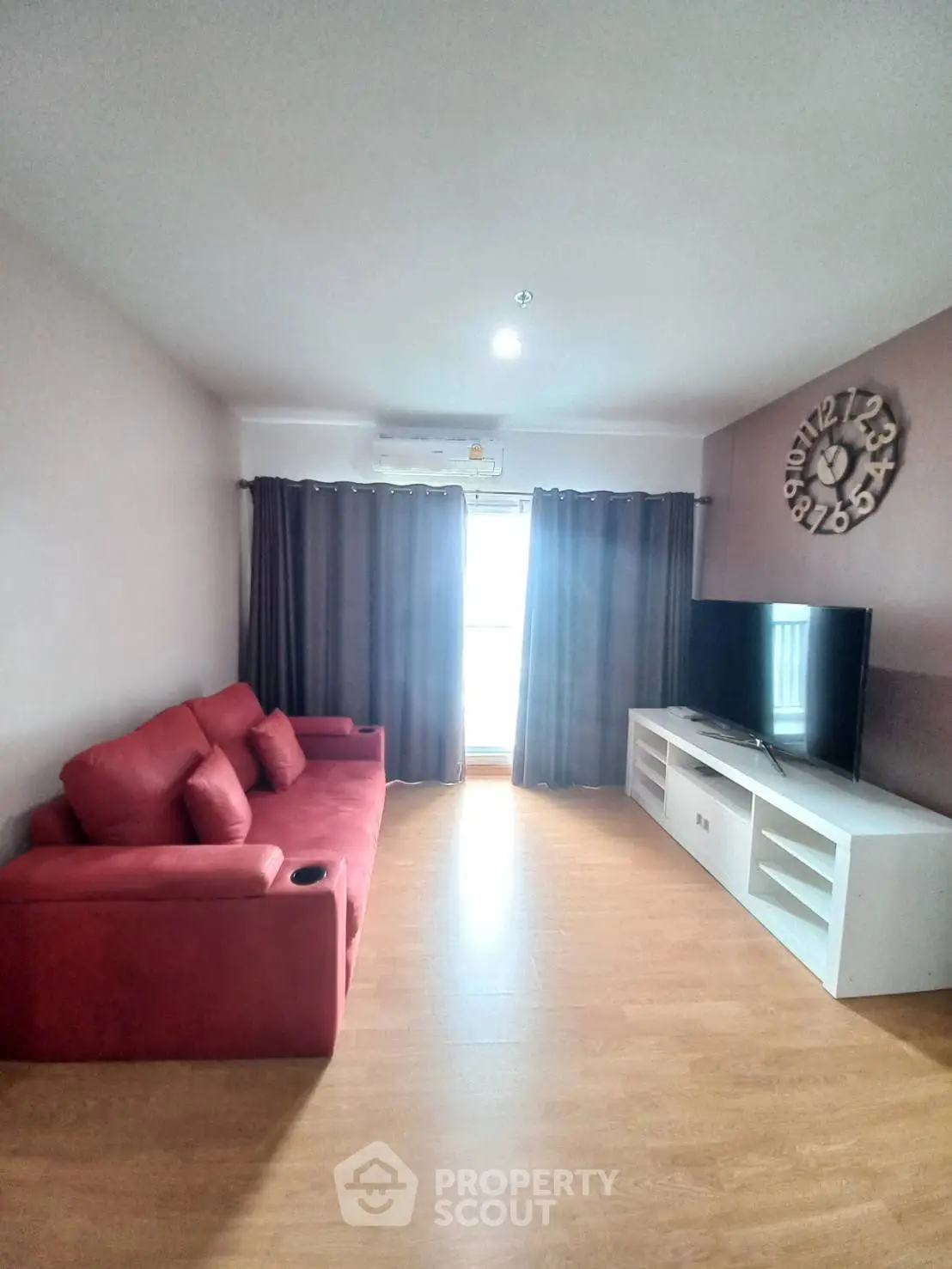 Spacious living room with red sofa and modern entertainment unit