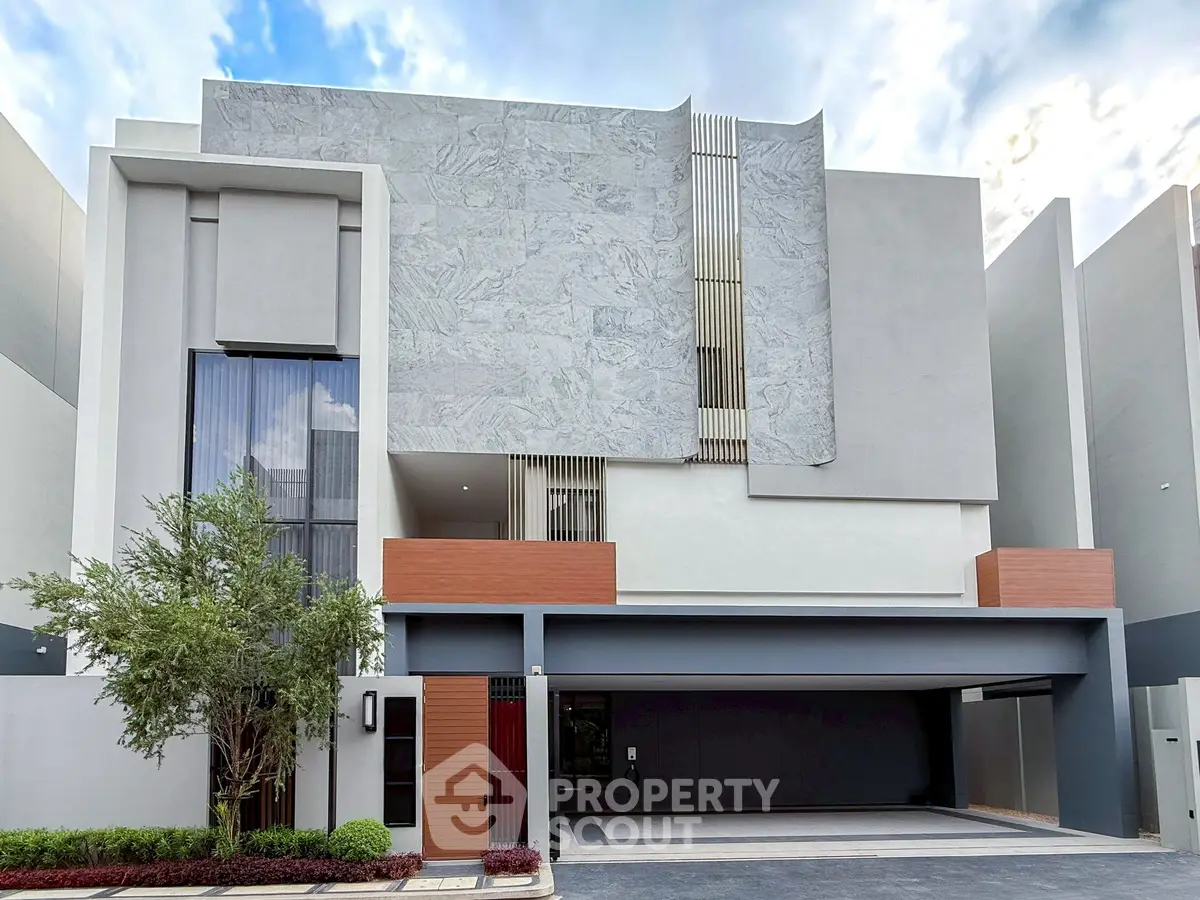 Modern architectural facade of a luxury residential building with sleek design and spacious garage.