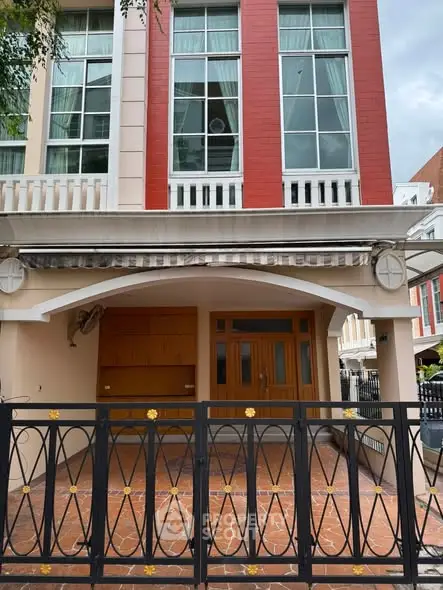 Charming townhouse exterior with modern facade and gated entrance, perfect for urban living.