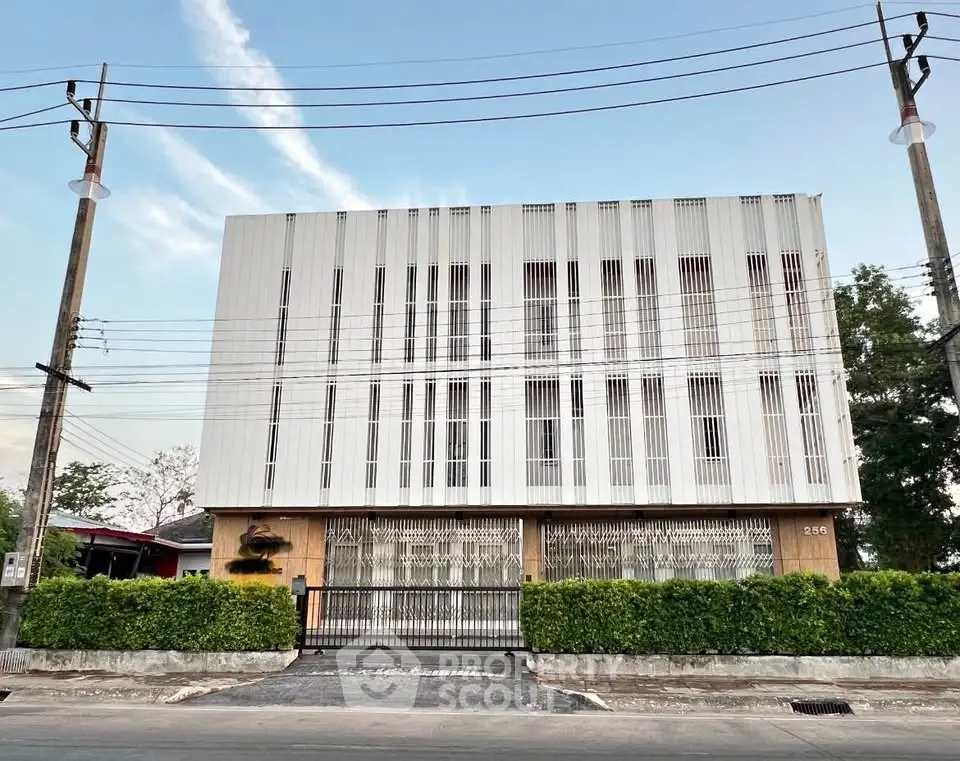 Modern minimalist building exterior with sleek facade and lush greenery