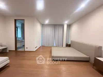 Spacious modern bedroom with minimalist design and wooden flooring