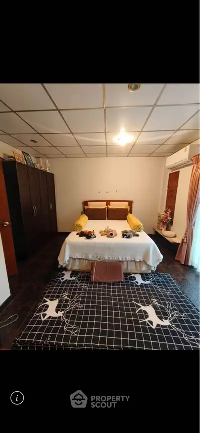 Cozy bedroom with stylish decor and ample natural light, featuring a comfortable bed and elegant furnishings.