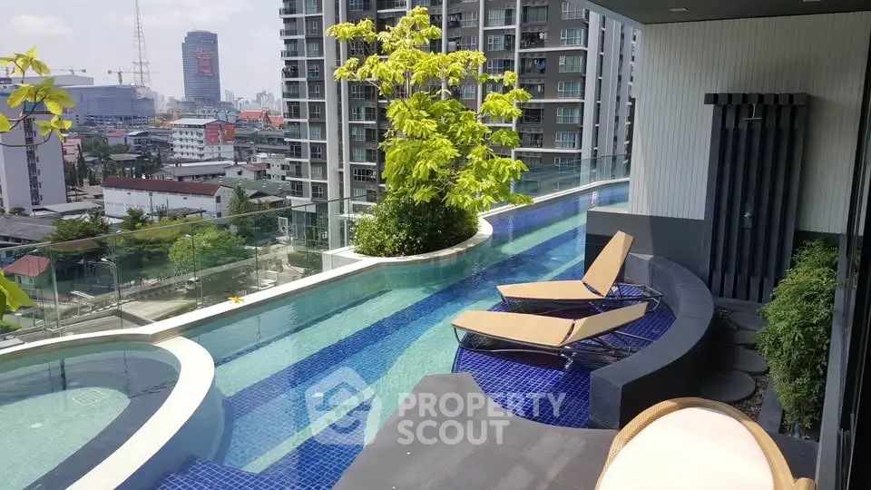 Luxurious rooftop pool with stunning city views and modern lounge chairs in a high-rise building.