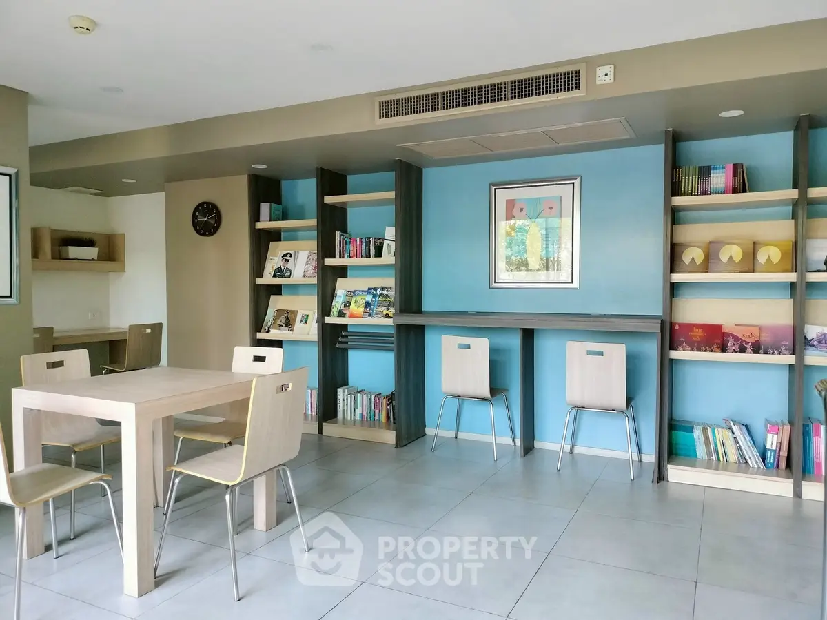 Modern library space with stylish wooden furniture and colorful bookshelves in a contemporary building.