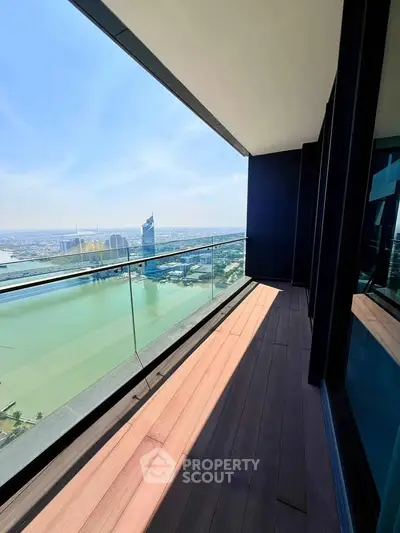 Stunning high-rise balcony with breathtaking city and river views, perfect for relaxation and enjoying the skyline.