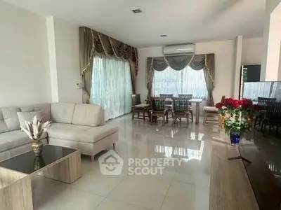 Spacious living room with elegant curtains and modern furniture, perfect for family gatherings.