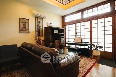 Elegant living room with leather sofa, piano, and Japanese-style sliding doors.