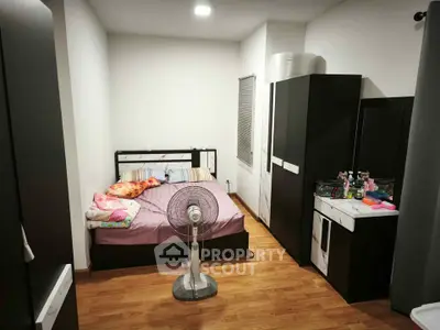 Cozy bedroom with modern furnishings and wooden flooring, featuring a comfortable bed and sleek storage solutions.