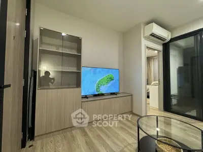 Modern living room with sleek furniture and large TV, showcasing a stylish and comfortable space.