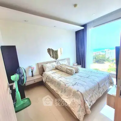 Bright bedroom with large window offering stunning city view, modern decor, and cozy ambiance.