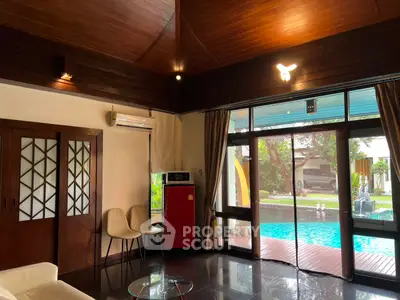 Luxurious living room with pool view and elegant wooden accents