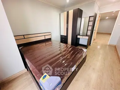 Spacious bedroom with modern furniture and wooden flooring in a stylish apartment