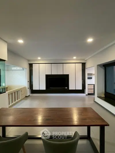 Spacious modern living room with sleek built-in entertainment center and elegant dining area.