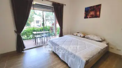 Cozy bedroom with garden view and sliding glass doors leading to patio.