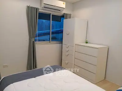 Cozy bedroom with modern white furniture and air conditioning, perfect for a comfortable living space.
