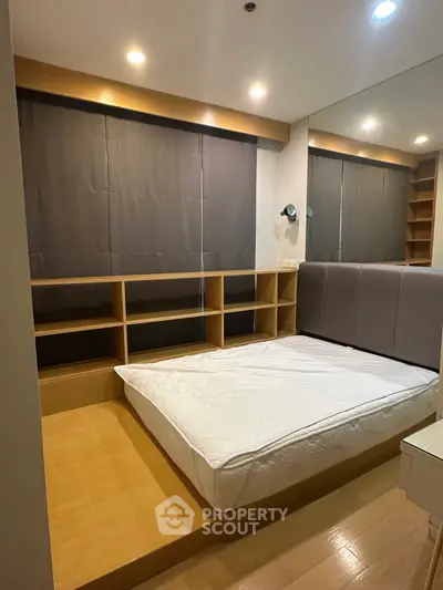 Modern bedroom with built-in shelves and cozy lighting, perfect for urban living.