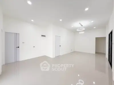 Spacious modern living room with sleek lighting and glossy tiled floors, perfect for contemporary living.
