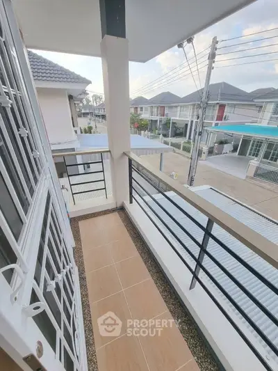 Charming balcony with modern railing and neighborhood view, perfect for relaxation and enjoying the outdoors.