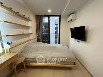 Modern bedroom with large window and wall-mounted TV in a stylish apartment.