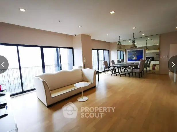 Spacious modern living room with elegant dining area and large windows.