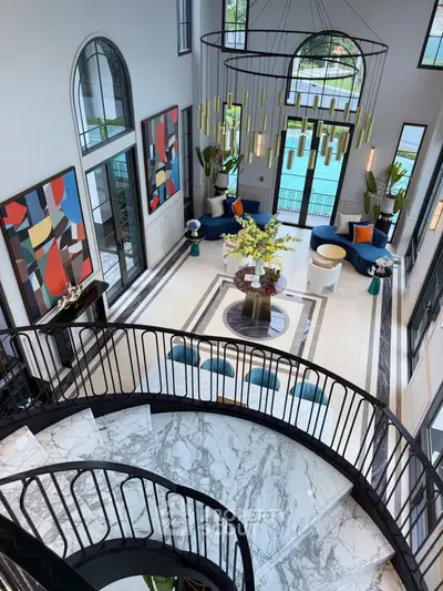 Luxurious modern living room with high ceilings and elegant marble staircase