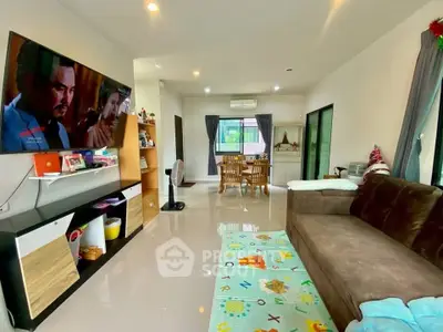 Spacious living room with modern decor and large TV, perfect for family gatherings.